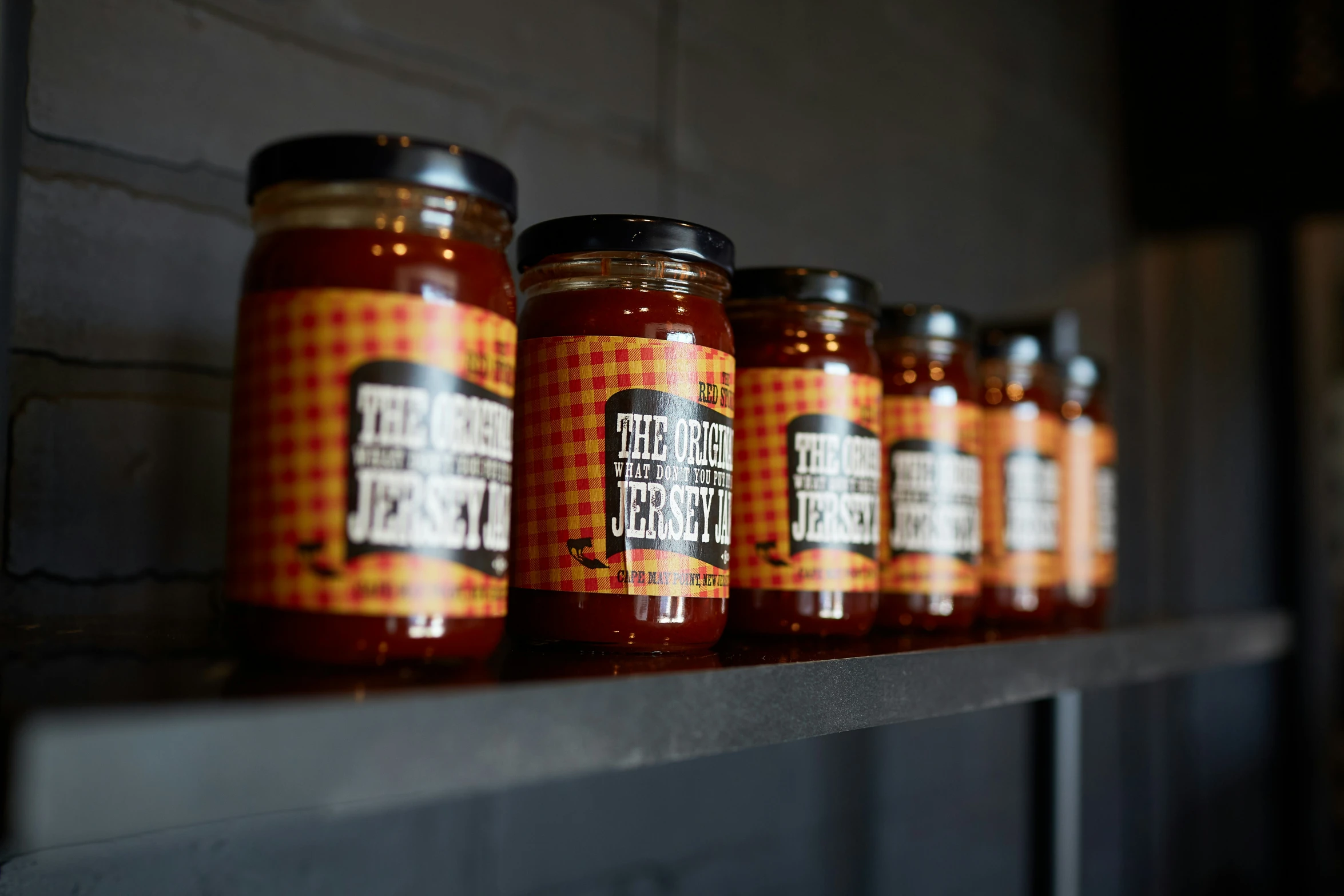 several jars of  sauce on a shelf