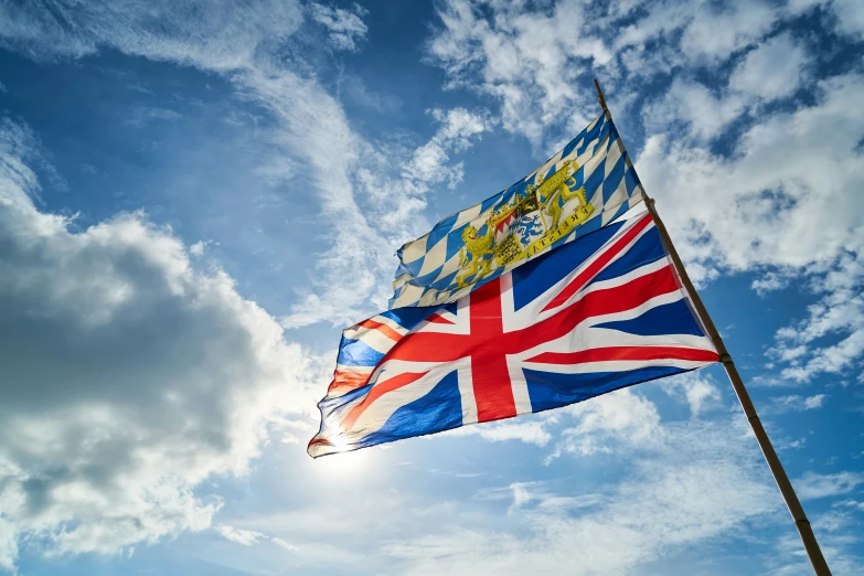 the british flag flies high above a partly cloudy sky