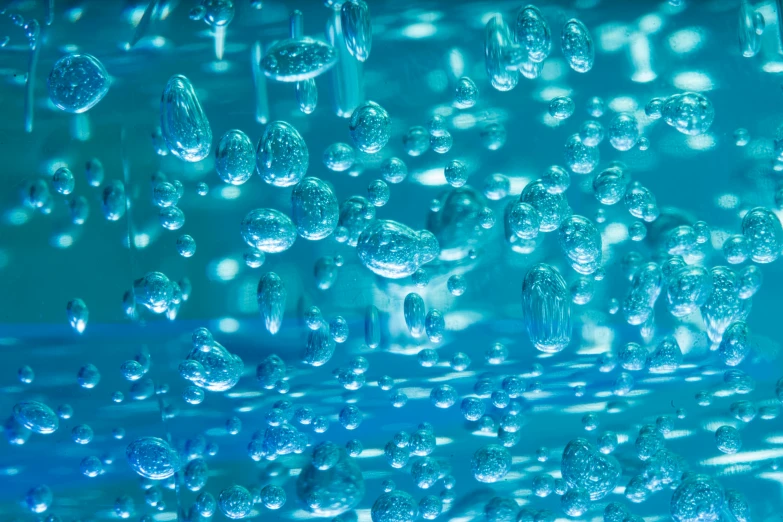 the reflection of water droplets in a blue glass vase