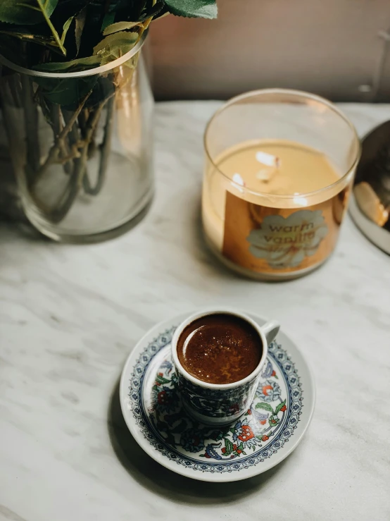 a cup of  chocolate and a vase with flowers