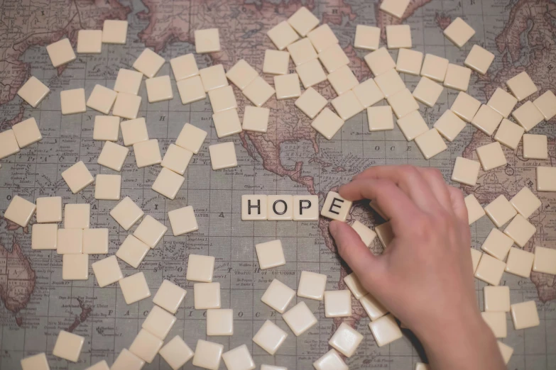 a person putting dices into the word hope on a map