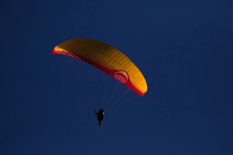 a parasailer is flying through the air while he has his parachute