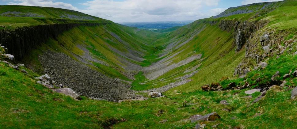 two large mountains with green grass and some rocks