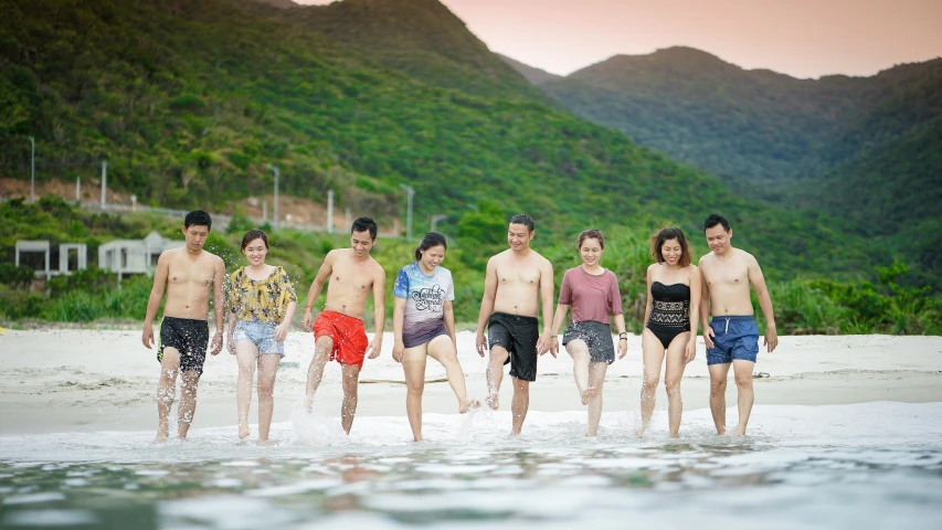 a group of people standing next to each other on a beach