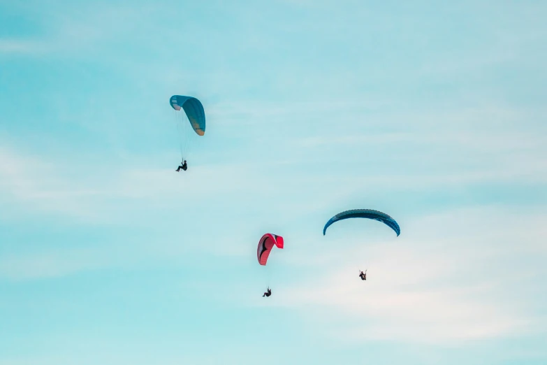 two people parachuting in the sky on blue skies