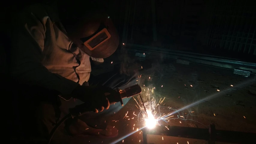 welders work with a machine  metal in the dark