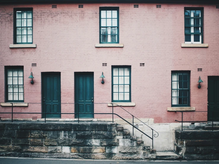 a building with stairs to other windows and a ramp leading to it