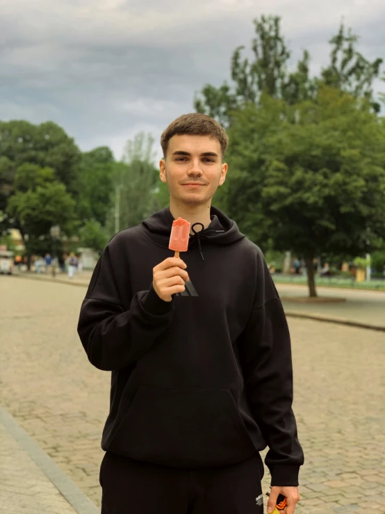 a man holding a candy bar and a cell phone