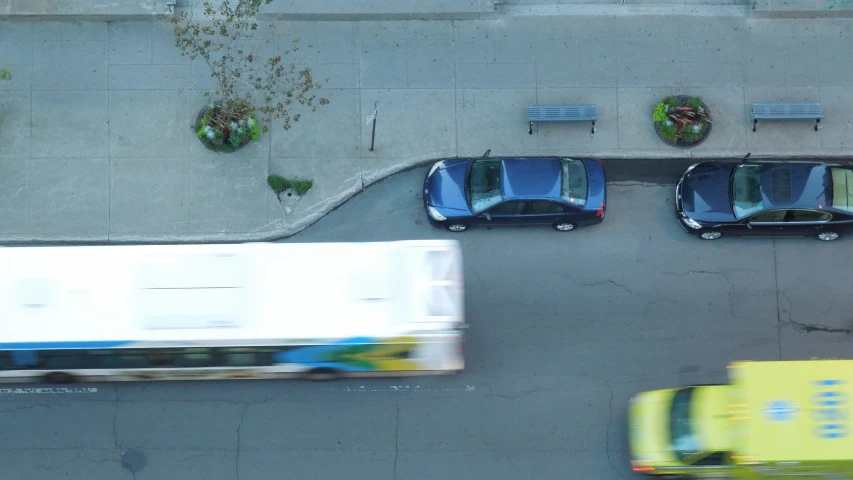 four cars traveling down an overhead street by a yellow truck