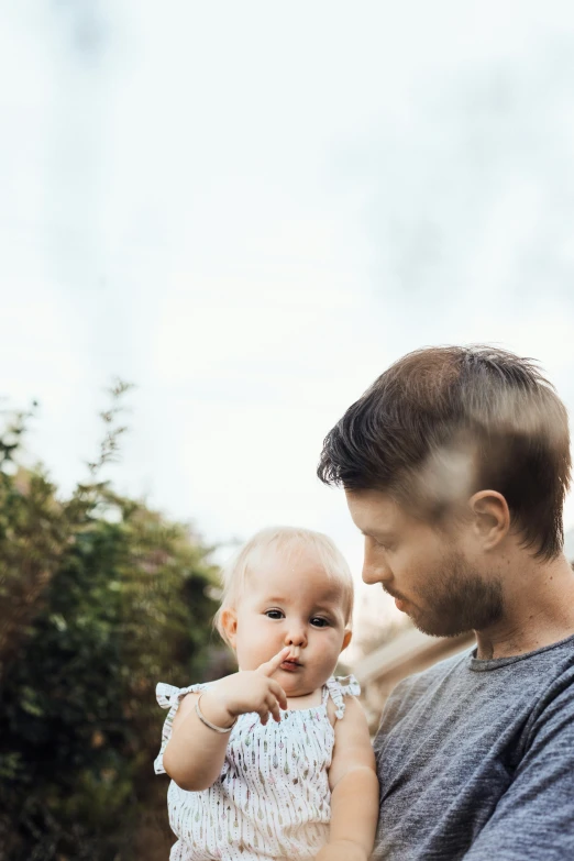 there is a man holding a baby while they look at soing