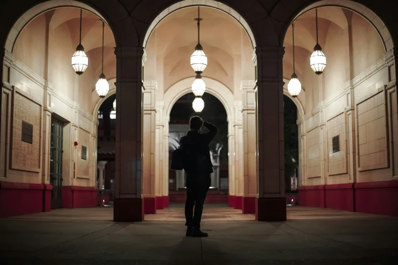 a man standing in a hallway looking through a window