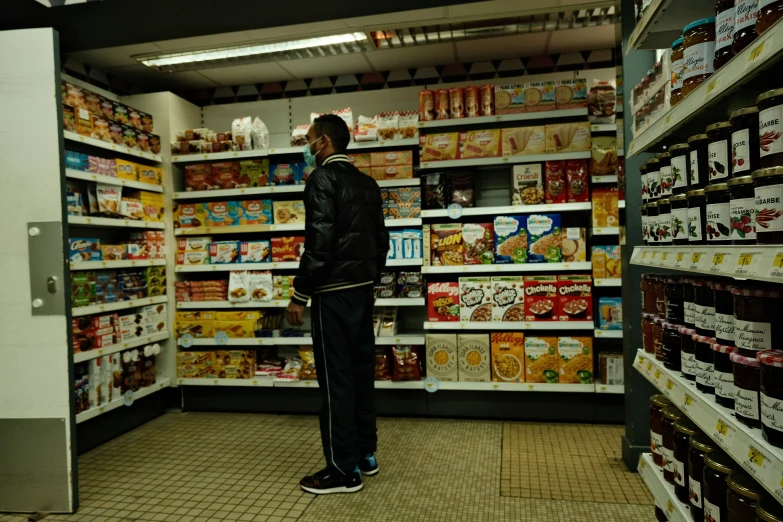 a man stands in a store, surrounded by shelves with cereal and yogurt items
