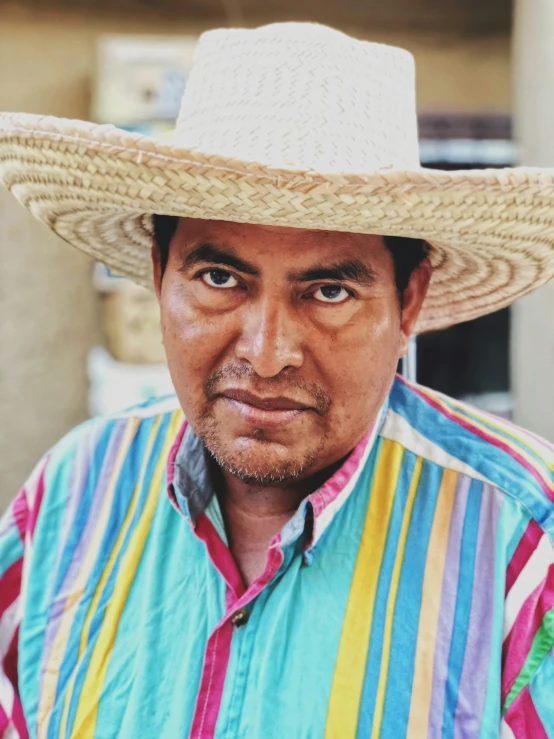 a man wearing a wide brimmed hat while posing for the camera