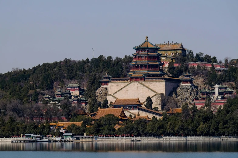 a building with some trees on top by the water