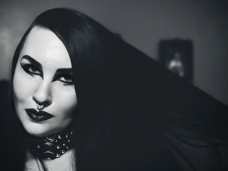 a woman with black and white makeup and piercing