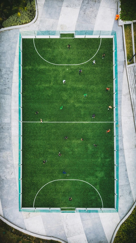 an overhead s of people playing soccer on an asphalt field