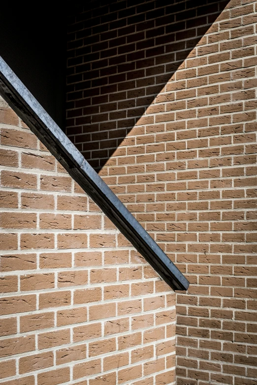 a corner of a brick building with a black window