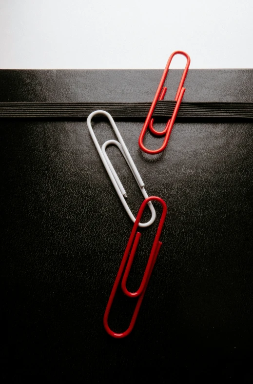 two red clips attached to a black surface