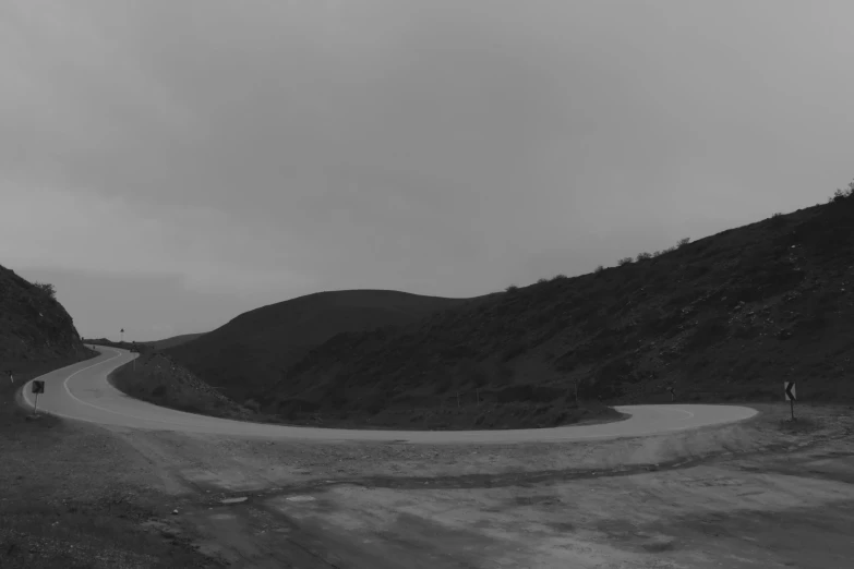 a black and white picture of a mountainous road