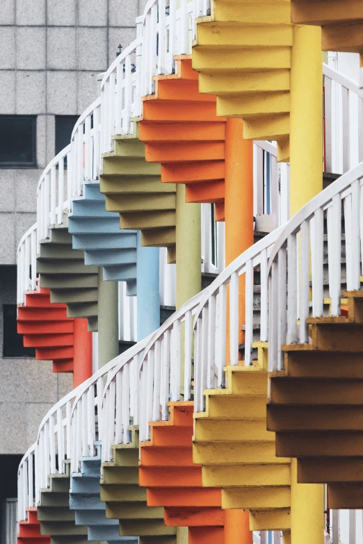 different colored and patterned staircases with brick building in background