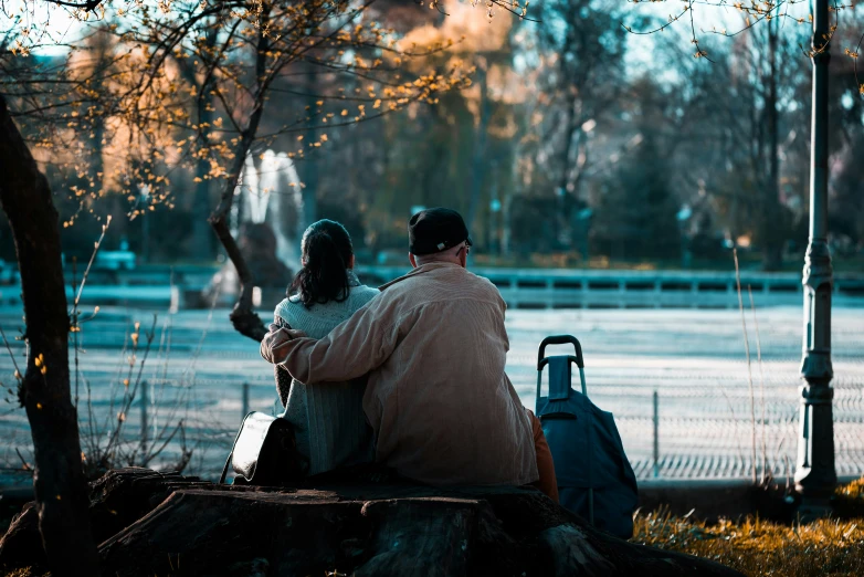 two people with a luggage and suitcase under a tree