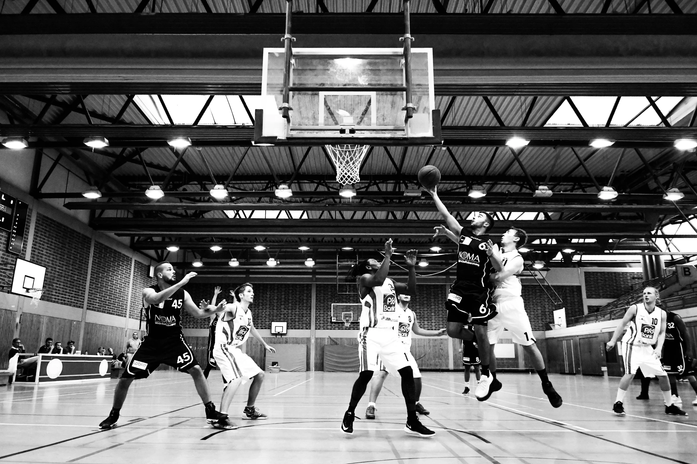 some guys playing basketball against each other in a gym