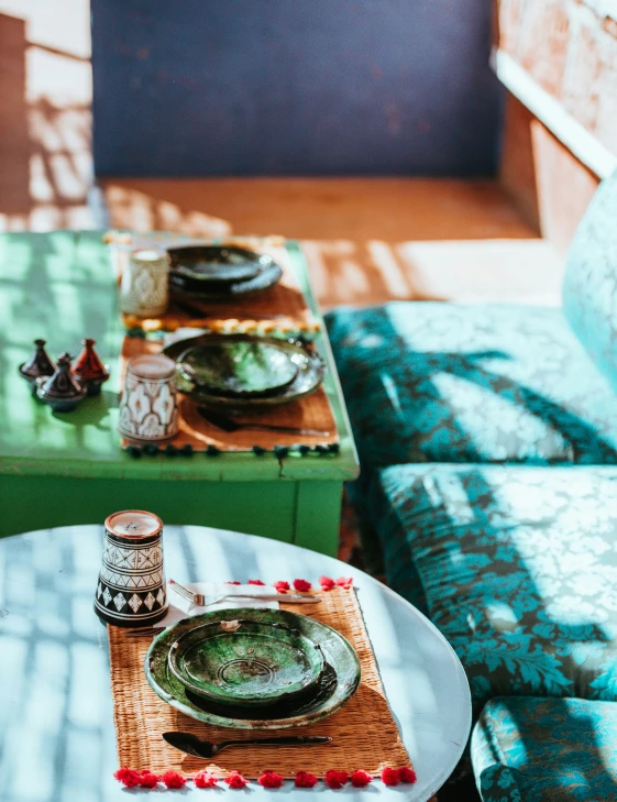 a green table and two blue patterned couches