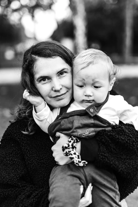 a woman holds a baby that is on her back