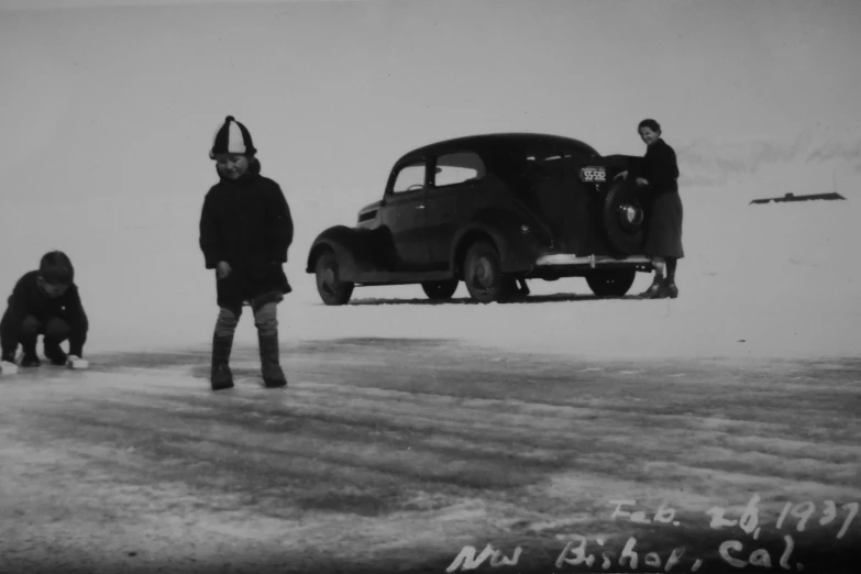 a man with a head scarf and two dogs standing by a truck