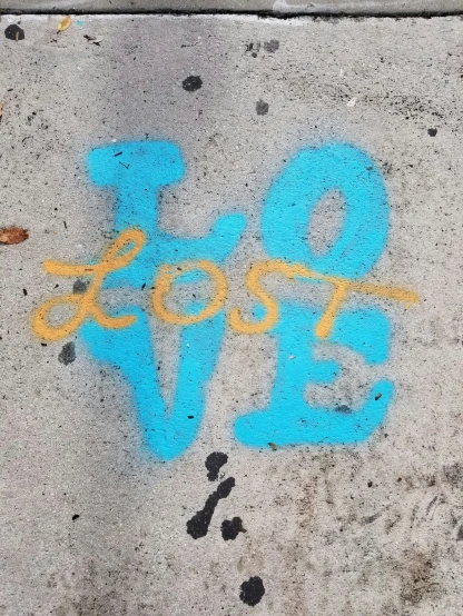 a colorful piece of graffiti spray painted on the sidewalk