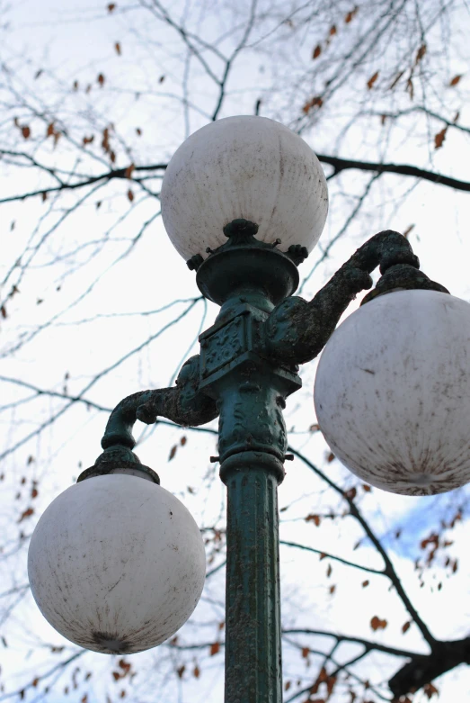 an old street light with two snow globe lamps