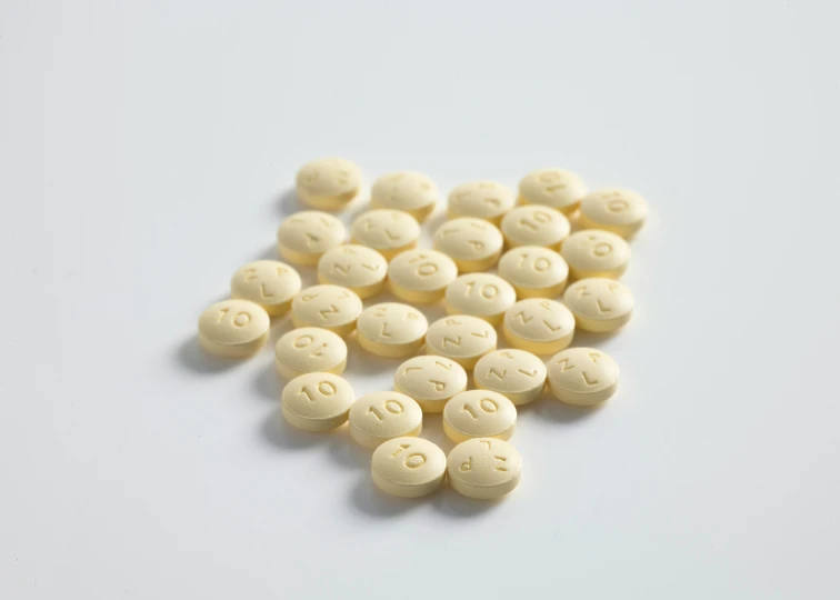 white pills scattered out in front of a white background
