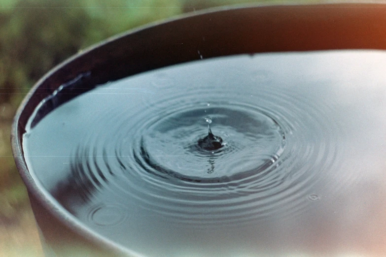 a large, black bucket with water is filled with ripples