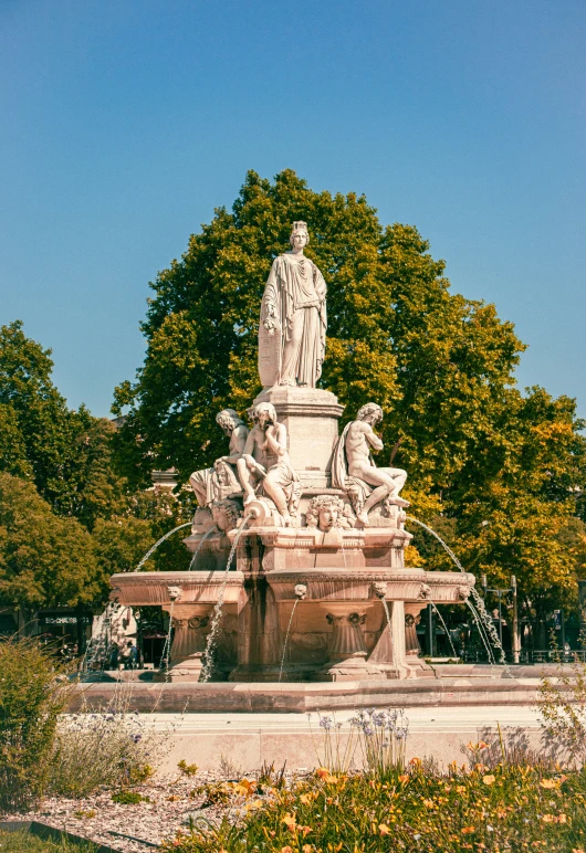 statue in the center of a park surrounded by tall trees