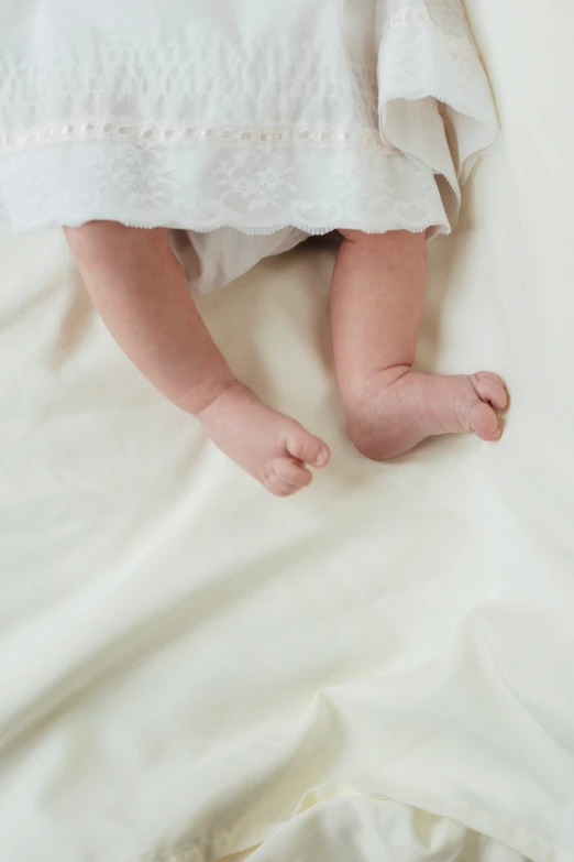 the baby is laying in his bed wearing no shoes