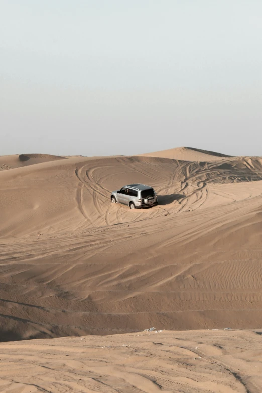 a van is stuck in sand on top of a dune