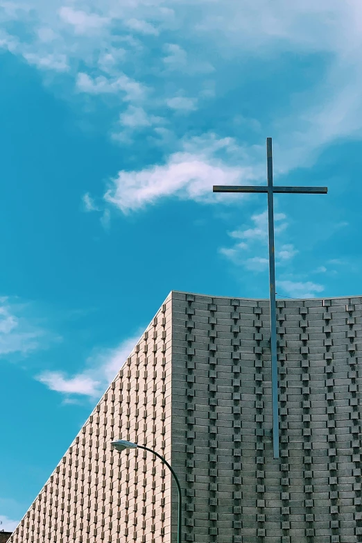 a cross stands at the top of an empty stone building