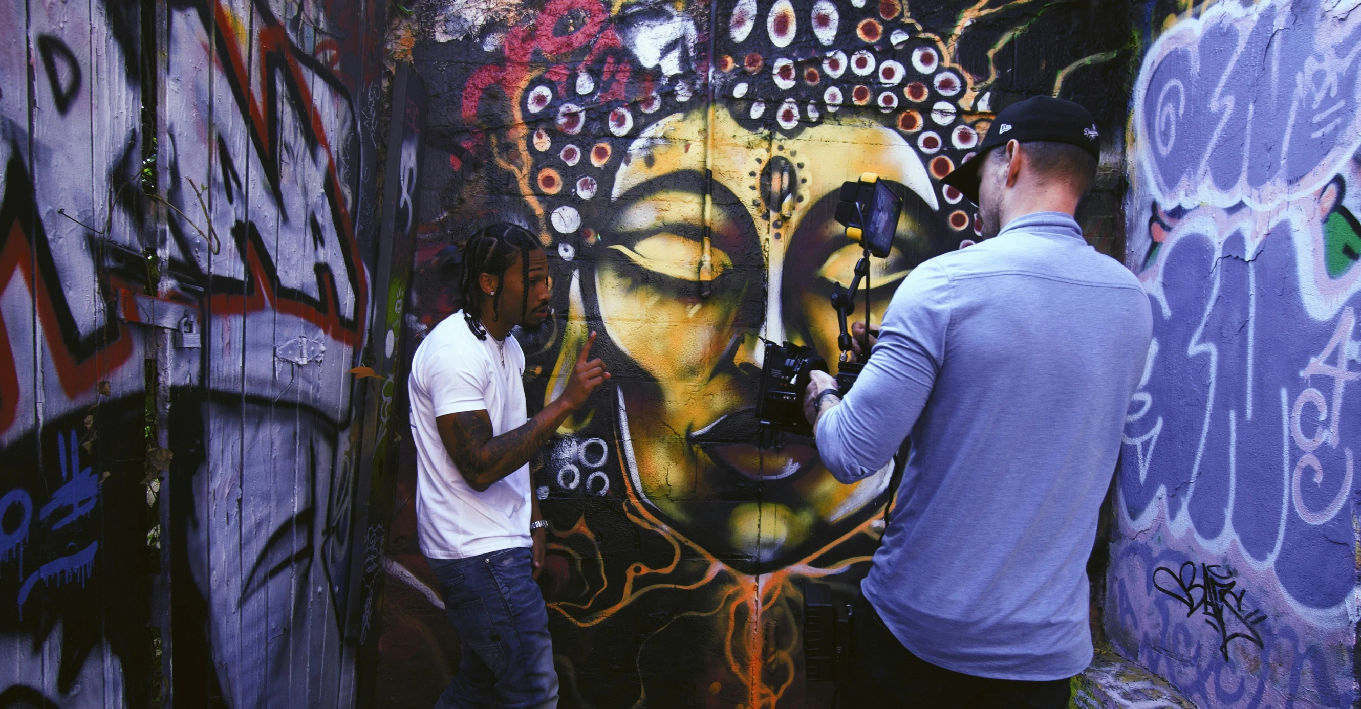 two men in front of graffiti in a city