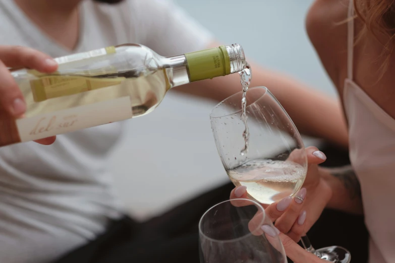 two woman drink wine in front of another