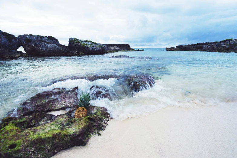 an ocean view with small rocks in the water