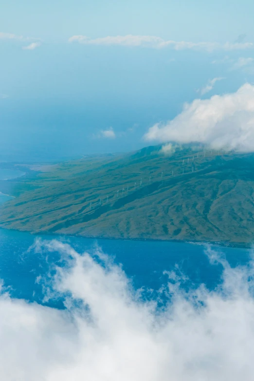 a bird flying over a small island in the ocean