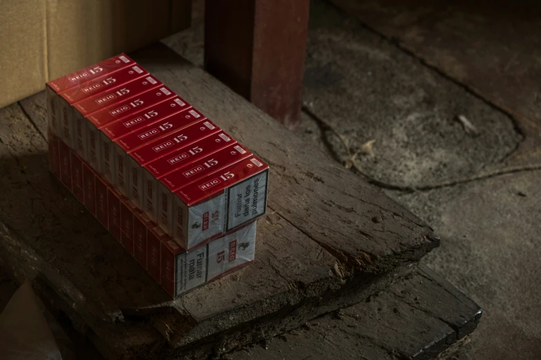 a stack of red boxes sitting on top of a wooden box