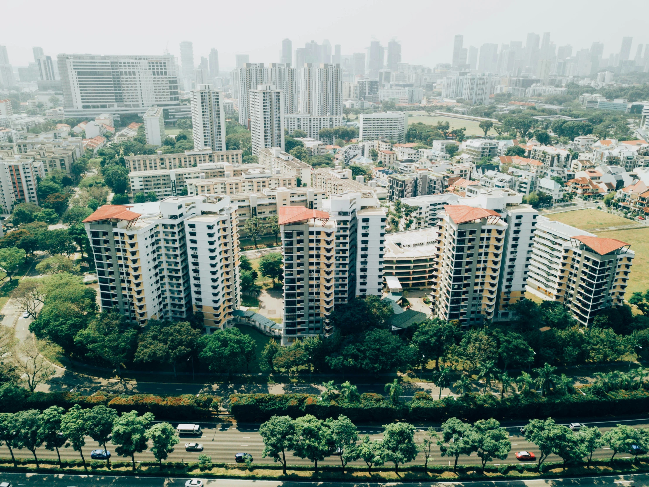 a bunch of apartment buildings with a long row of trees