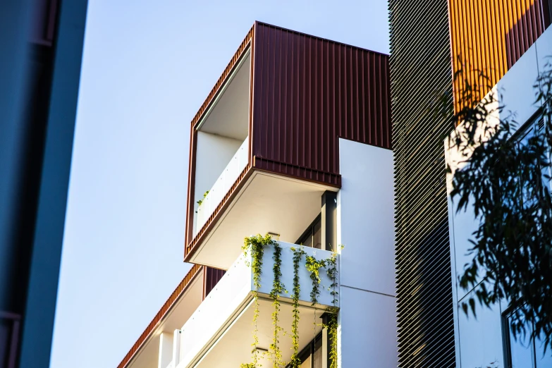 a tall building with green plants growing from it