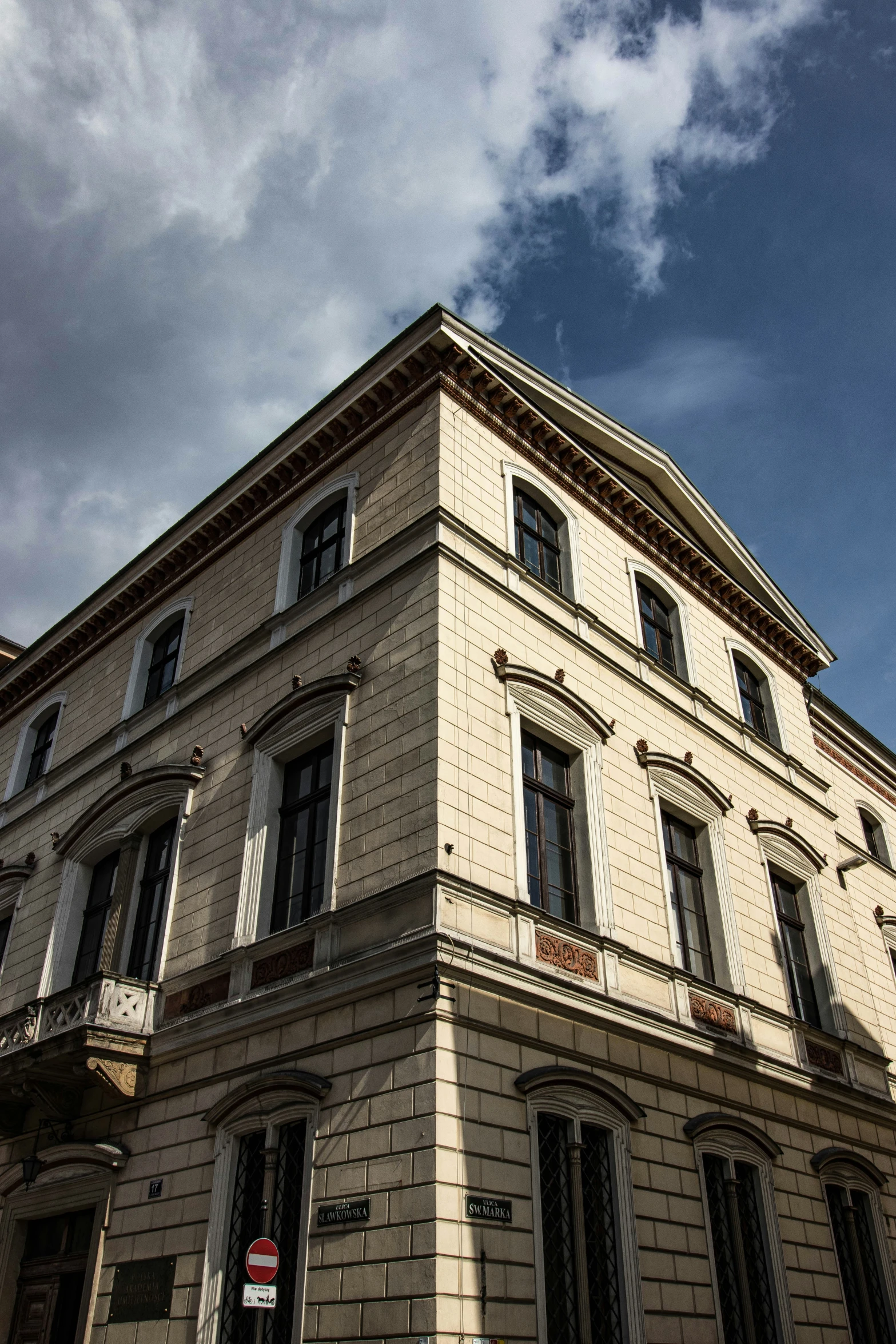 the corner of a building with two balconies and windows