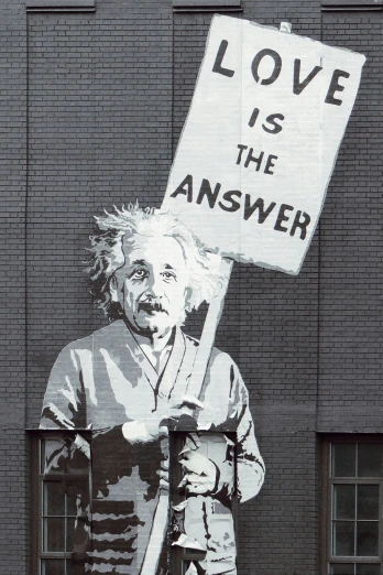 a political poster of the famous person holding a sign that reads love is the answer
