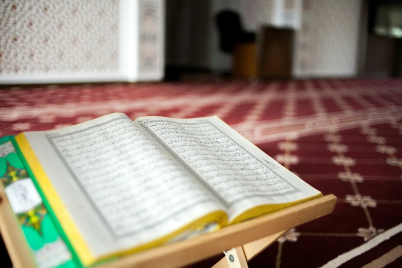 a open islamic book on a table in a house