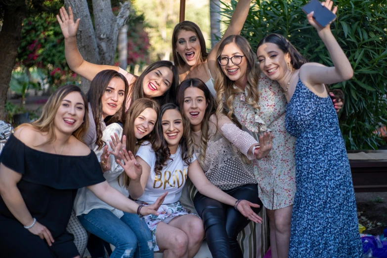 a group of women posing for a picture with one woman holding up her hand