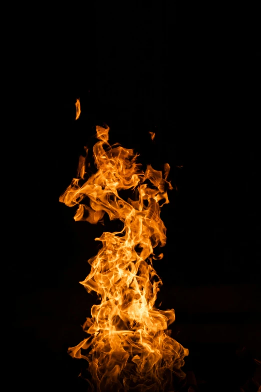 some flames on a black background with one being lit by a red flash