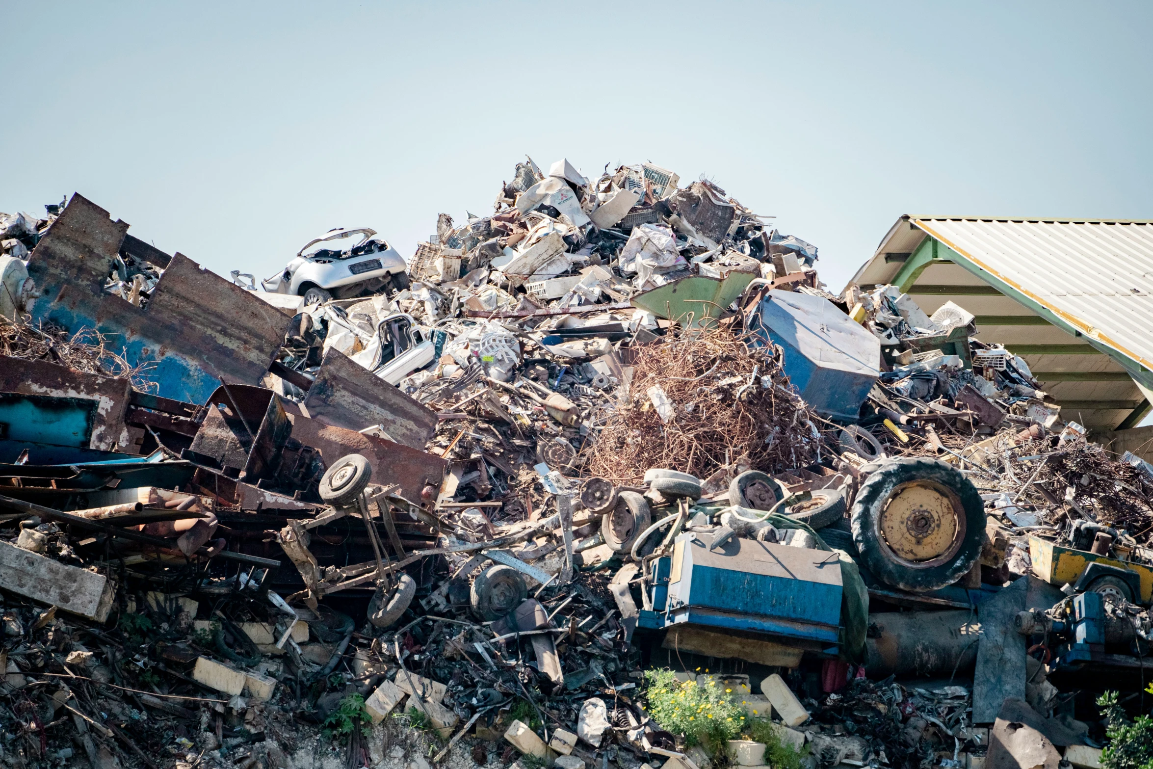 a pile of garbage with cars and building in the background